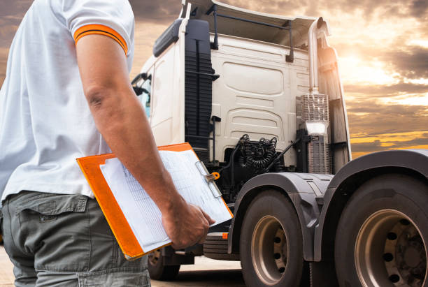 Truck inspection maintenance and repairing. A truck driver holding clipboard his checking safety to before driving semi truck.